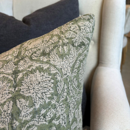 Introducing the Paradise Block Printed Linen Green Cushion crafted by Chamois, a renowned Swedish interior and fashion brand. This stunning addition to your home decor features a traditional Indian block print in a dark blue and natural hue pattern, and is made with 100% Belgian Linen for its superior quality and durability. To ensure maximum comfort, a quality feather insert is also included. Corner close up.