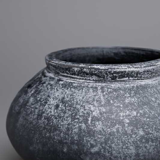 Black textured pot on a gray background
