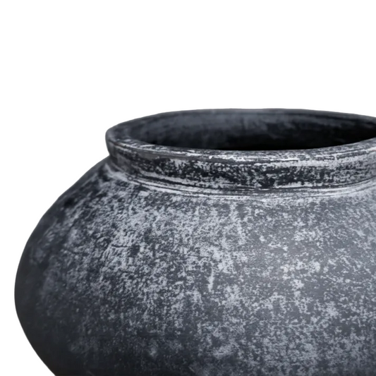 Black textured pot on a gray background