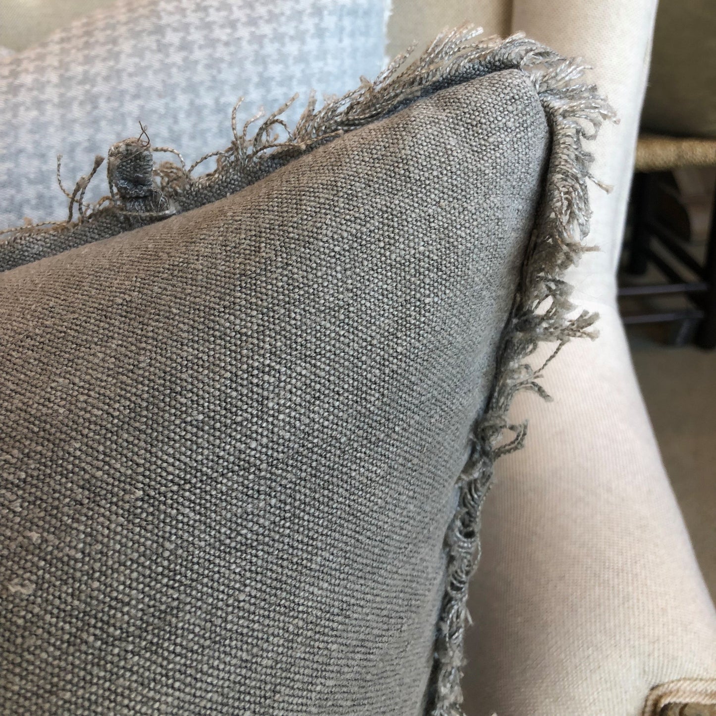 The Matera Stonewashed French Linen Blue Grey Cushion evokes rustic elegance, offering refined textile for soft-furnishing and offers a soft and comfortable feel and touch. Includes a plush feather-filled insert. Close up corner.