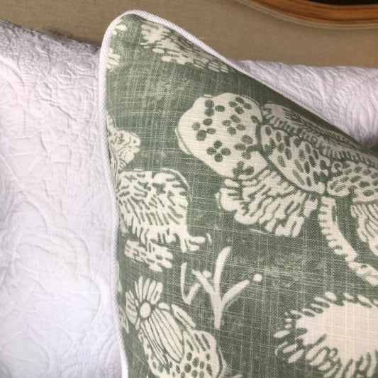This elegant Richloom Platinum Howland Linen Moss Green Cushion is crafted from Richloom's global fabric house, featuring a graceful white pattern of trees and birds on a pale green background. Its sumptuous heavyweight fabric and the luxurious feather insert make it a perfect accent for your plush home decor. Corner close up.