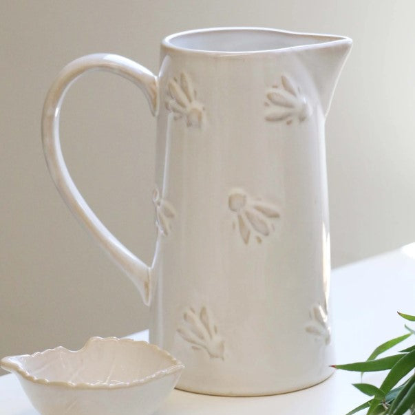 Experience the exquisite design of the Abeille Bee Cream Ceramic Jug, with an embossed bumblebee design and glossy cream-colored glaze. Perfect for holding water or displaying beautiful flowers, this jug adds a touch of elegance to any kitchen. Plus, its large, comfortable handle makes it easy to use.