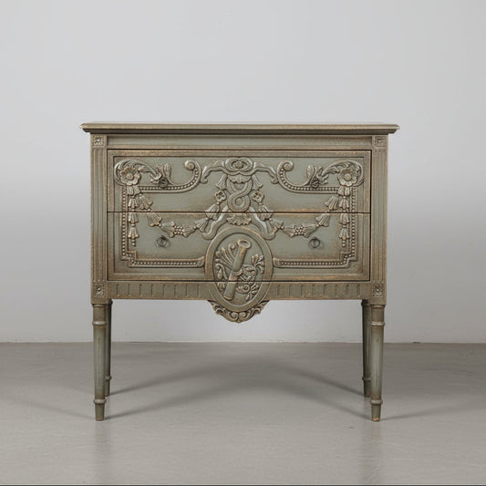 The unique and stunning one of a kind Daphne Sideboard boasts intricate carvings and distressed pale olive/grey painted finish. Crafted from mahogany and featuring two drawers, this versatile piece is perfect for a living or dining room in even in a bedroom. Front