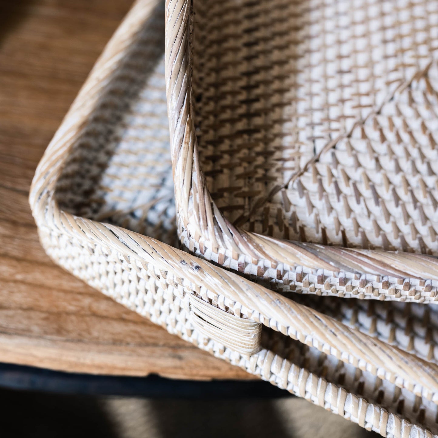 The Handmade Bulan White Washed Rattan Tray was crafted where the history of basket-weaving goes back many centuries. It has a light whitewashed finish that gives off a calm vibe and it can easily transport plates and glasses from the kitchen to the dining table, or it can be placed as decoration on a coffee table or ottoman. Detail styled.