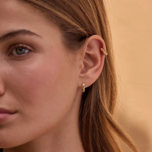 The Alida Topaz Huggies pack a real punch with hand-picked gemstones. You get a lustrous pearl, deep London blue topaz, sky blue marquise topaz, and warm citrine - all bezel-set into a golden hoop. 