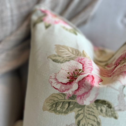 Experience the charm of the Ava Floral Print Linen Cushion - a favorite among our team. The delicate blend of sage green leaves and blush pink petals on a subtle, soft green background creates an elegant and beautiful addition to any space. Corner Close-up