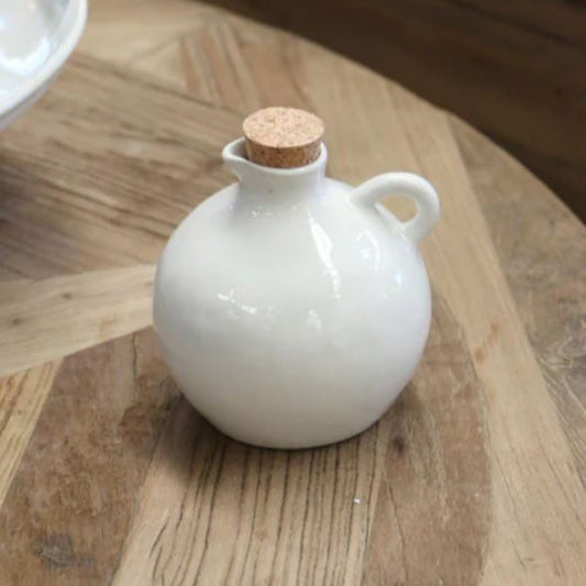 The Creamery Handcrafted Oil Pourer showcases a graceful organic shape, texture, and color that highlight its distinctive appeal. Crafted from sturdy stoneware and finished with a soft ivory cream glaze, it offers a timeless design perfect for daily use. Dishwasher, microwave, and oven safe, this elegant oil pourer combines functionality with style, making it a stunning addition to any kitchen display.