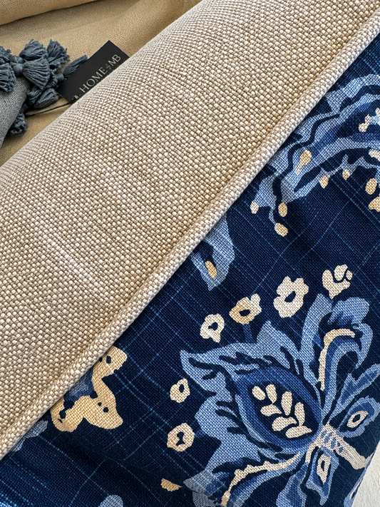 Close-up of a woven textile product showing a beige textured side, a navy blue patterned side with cream floral motifs, and a small black tag reading 'LUMIÈRE'.