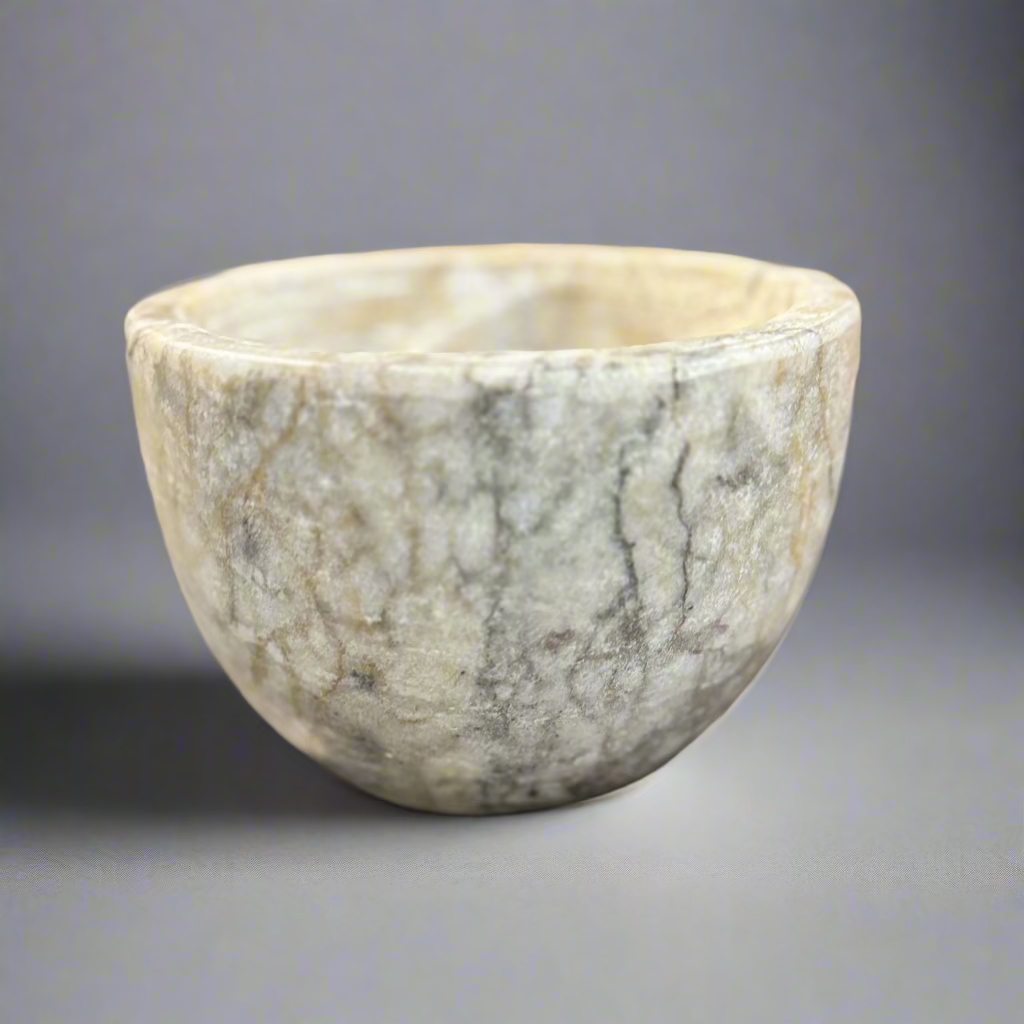 Indulge in the captivating combination of off-white, brown, and grey hues found in our Sangiran Stone Bowl. Its exquisite, handcrafted design brings a touch of sophistication to any room. Ideal for showcasing on a coffee table, console, or bedside, it also doubles as a functional holder for precious trinkets, meticulously carved by skilled artisans in Southeast Asia.