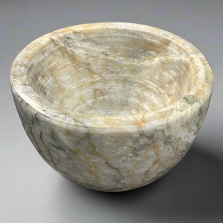 Indulge in the captivating combination of off-white, brown, and grey hues found in our Sangiran Stone Bowl. Its exquisite, handcrafted design brings a touch of sophistication to any room. Ideal for showcasing on a coffee table, console, or bedside, it also doubles as a functional holder for precious trinkets, meticulously carved by skilled artisans in Southeast Asia.