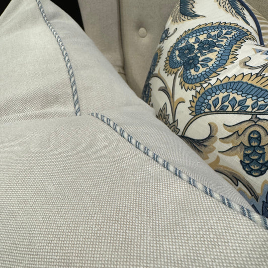 Transform your living space with our Stone Cotton Canvas Cushion, meticulously designed using premium materials. Its understated sophistication creates the perfect backdrop for more vibrant, patterned pieces in your collection. The distinctive blue ticking stripe piping adds a refined touch, while the luxurious feather filling ensures unparalleled softness and comfort for everyday lounging or decorative display.