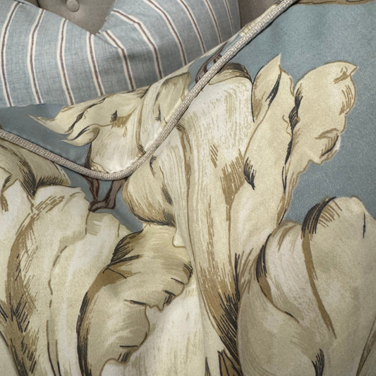 This stunning Peony Floral Cushion in Duck Egg Blue is crafted from a premium cotton blend fabric showcasing an elegant floral design in cream and taupe. Filled with soft feathers, it offers exceptional comfort, complemented by natural self-piping for a refined finish.