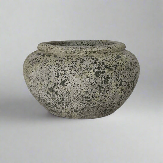Speckled gray pot on a light gray surface with a white background