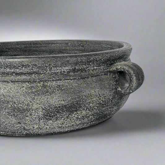 Textured black pot on a light gray background