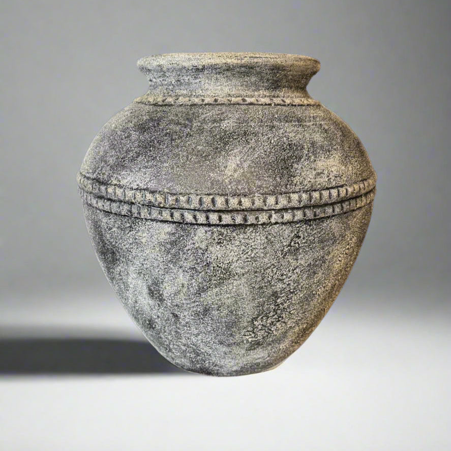 Textured stone urn on a gray background