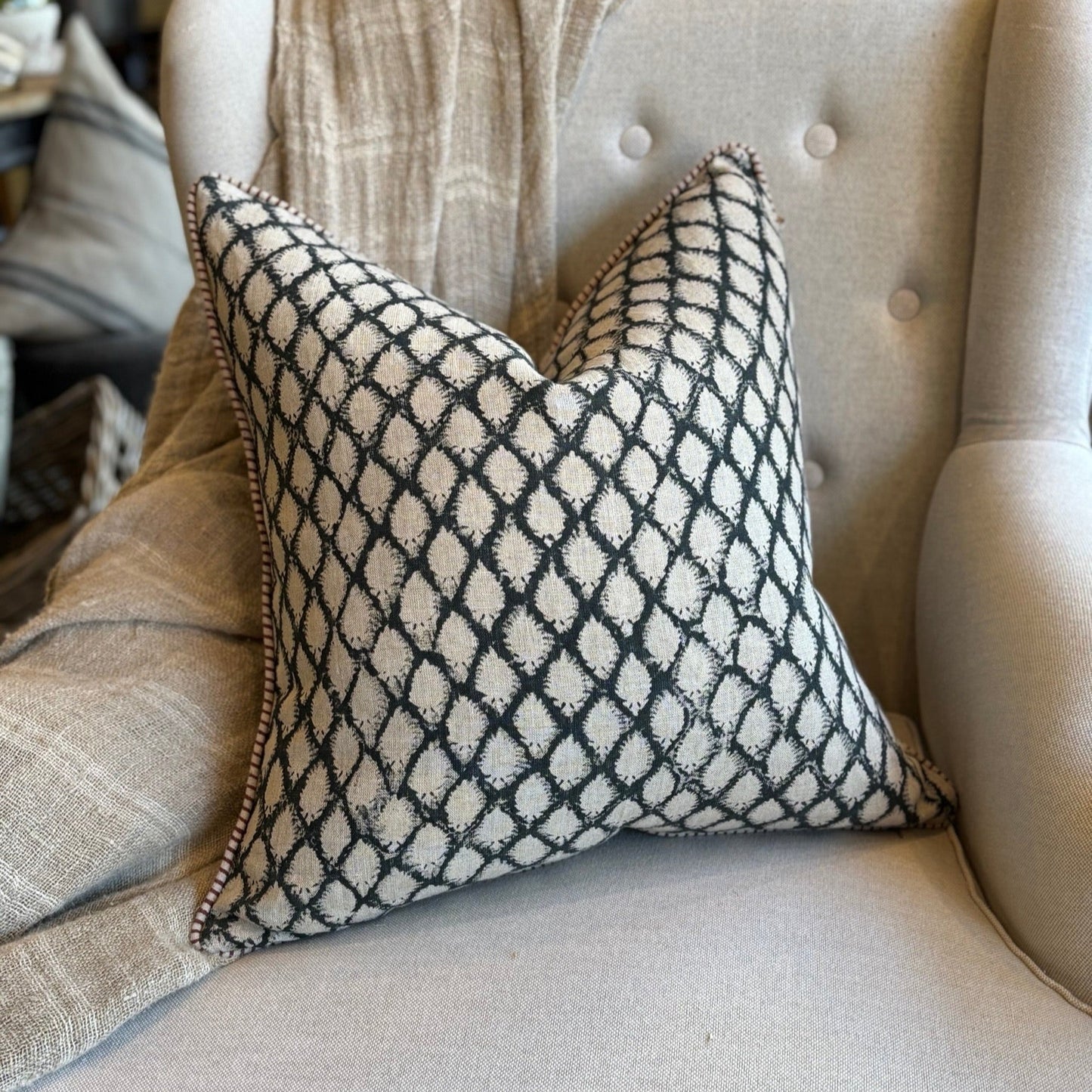 Decorative pillow with black geometric pattern on a beige sofa