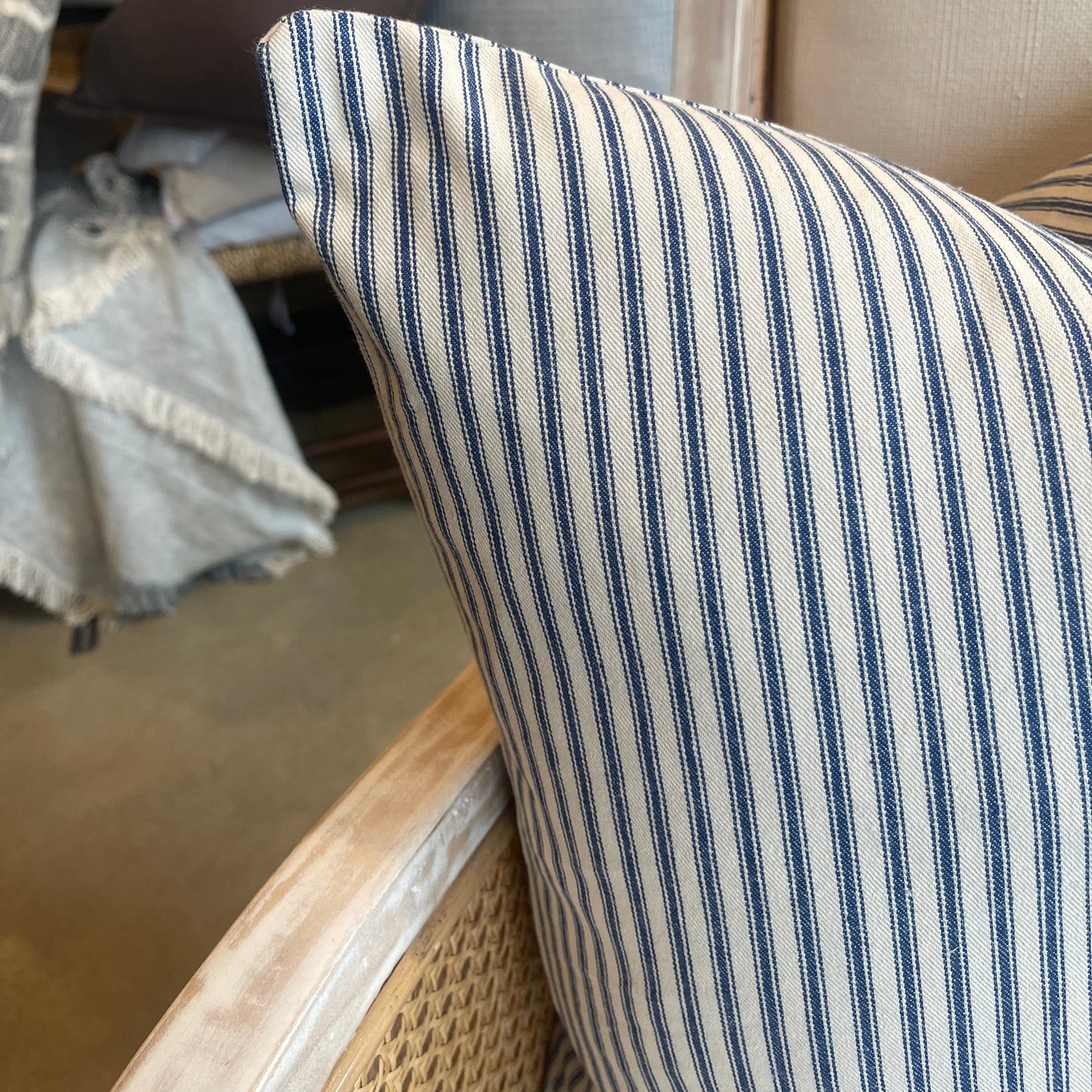 This 50cm x 50cm Navy Ticking Stripe Linen Cushion, made with Warwick Fabric's natural linen, features a timeless elegant pattern. Its heavyweight structure provides an air of sophistication, and its soft feather insert ensures luxurious comfort. Create a statement with this piece by pairing it with either solid or patterned companions. Corner close up