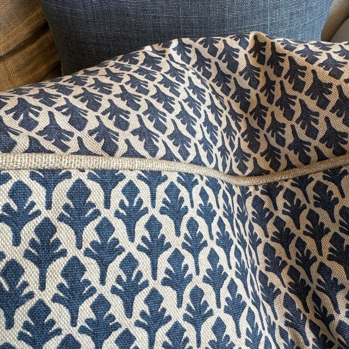 Close-up of a fabric with blue and beige pattern on a sofa.