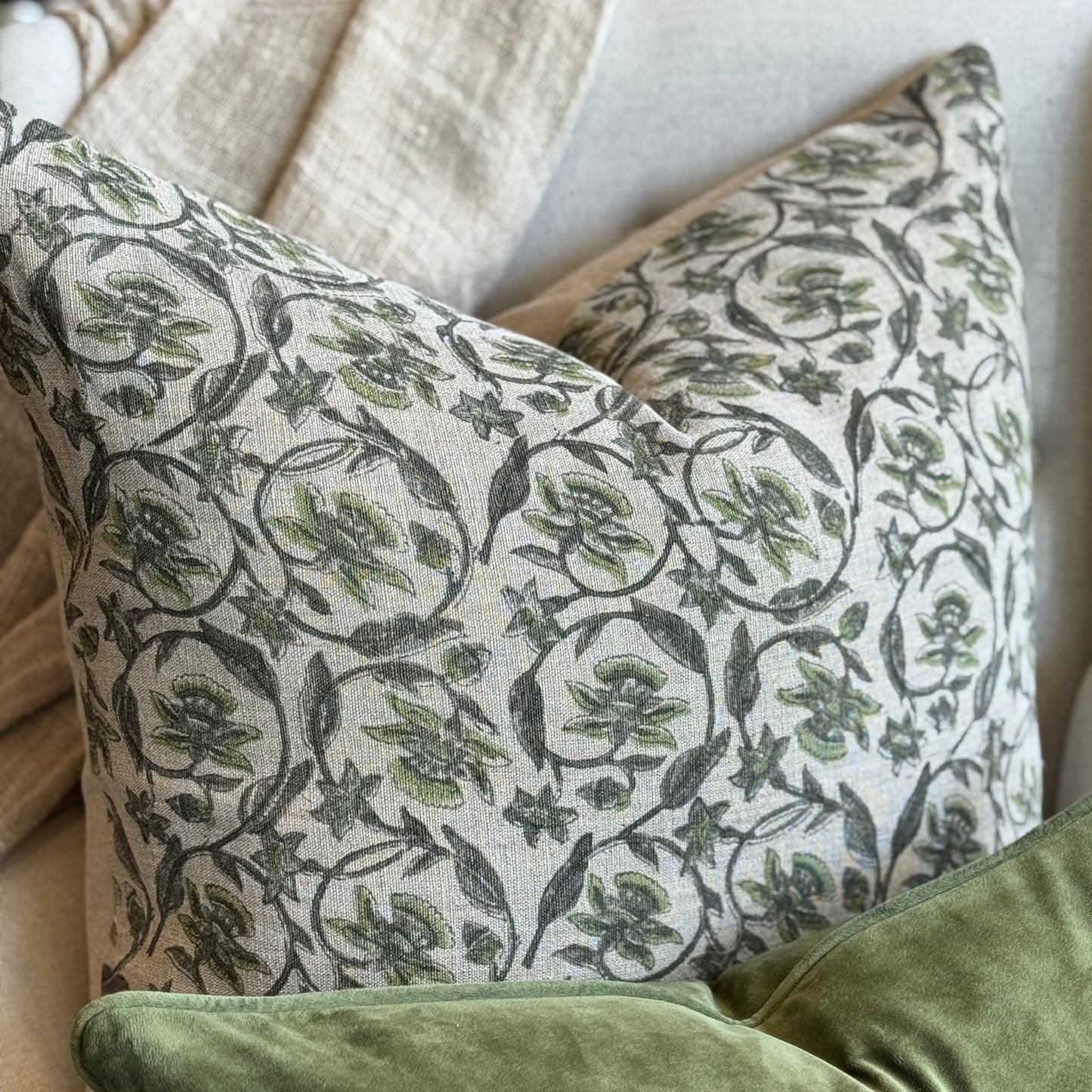 Patterned and solid green pillows on a sofa