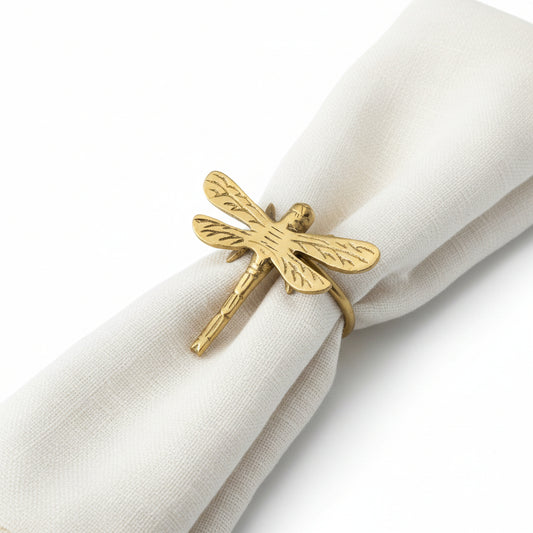 Gold dragonfly napkin ring on a white napkin