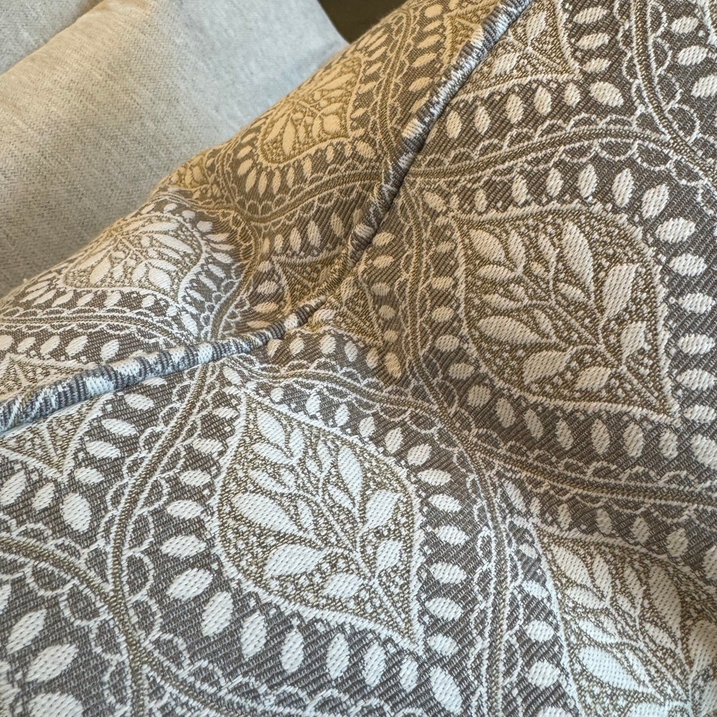 Patterned fabric draped over a chair with a neutral background