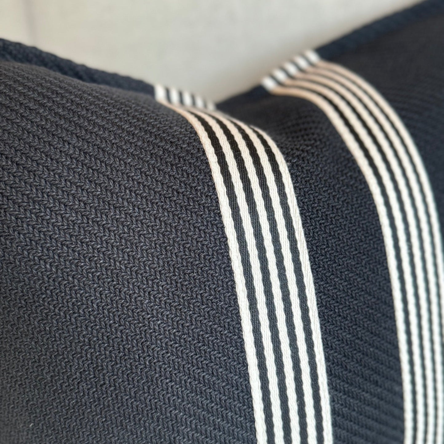 Channeling the sleek elegance of Milano's fashion district, each Black & White Herringbone Striped Cushion features the striking contrast of black and white, evoking the timeless beauty of the marble found in both ancient Italian villas and modern Milanese ateliers. Styled.