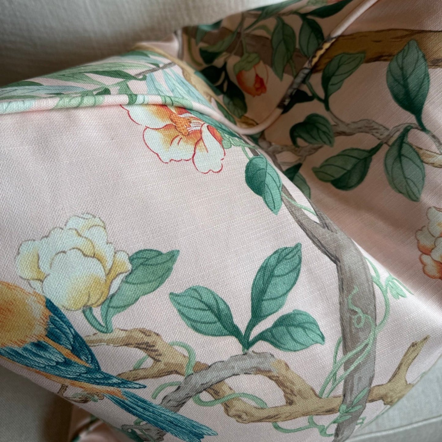Experience the beauty of nature with this vibrant apricot pink cotton cushion, featuring charming birds, delicate butterflies, and lush botanicals. Add a pop of color to any space and elevate your home decor with this lovely accent cushion, complete with a soft duck feather insert.