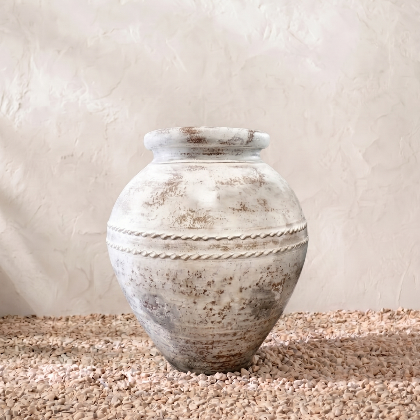 Decorative terracotta pot on a textured surface with a neutral background