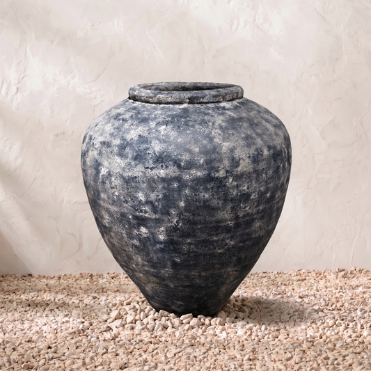Vintage-style terracotta pot on a textured surface with a neutral background