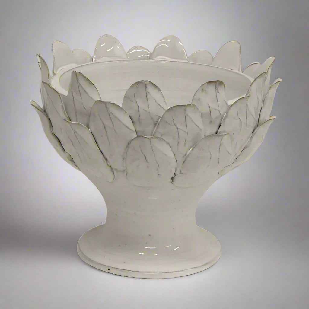 Handcrafted from terracotta and finished with an off-white glaze, this elegant Artichoke Leaf Bowl is the perfect addition to any dining or coffee table, or even a console. Its versatile design makes it equally suitable as a decorative object or a functional serving vessel.