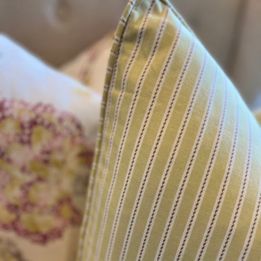 Experience unbeatable comfort with the adorable Penelope Cotton Ticking Stripe Cushion! Featuring a subtle ticking stripe and a playful pastel lime color, this cushion is sure to add a touch of fun to any space. Complete with a feather insert, it's the perfect combination of style and coziness. Close-up