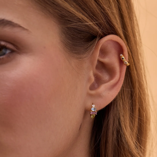 Hand-cut gemstone hoops featuring Sky Blue Topaz, Amethyst, and Peridot with Cubic Zirconia accents. Classic claw setting showcases the crystals beautifully. A striking statement piece for any ear.