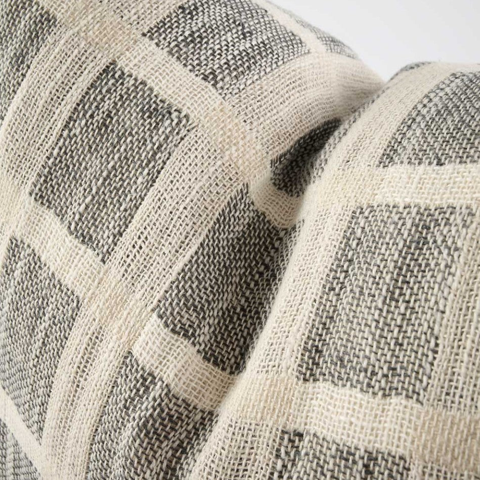 An embodiment of understated elegance, the Chloe Linen Criss-Cross Lumbar Cushion is inspired by the cobbles stones of Greece, featuring a luxe weave pattern that captures the eye. Add the matching throw and other pieces from our collection to create a beautiful ensemble, or let the cushion stand on its own. Filled with the exclusive, ultra-comfortable plump feather insert , crafted from linen/cotton yarn dyed check and is OEKO-TEX® and GOTS certified. Close up.