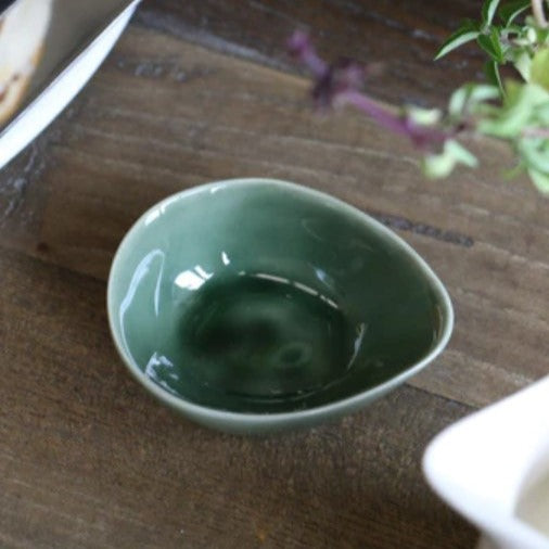 This charming bowl, featuring a soft dark green hue and subtle glaze finish, is ideal for olives, condiments, and salt. Combining traditional style with contemporary flair, this elegant piece is perfect for formal occasions or everyday use. The Verde Ivy Petite Bowl stands out with its romantic appearance and classic green colouring, seamlessly transitioning between settings. Styled.