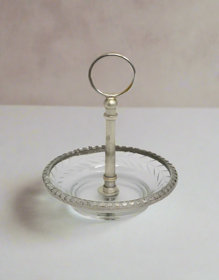 This beautiful Dish carved from brass with a stylish aged silver finish features a graceful cut glass handle. Its ideal size to hold your most meaningful pieces of jewellery and can be placed on your nightstand.