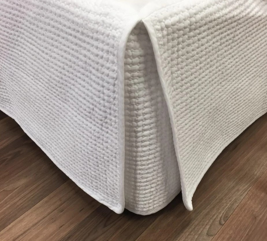 Indulge in the timeless elegance of the Avignon Valance, perfect for enhancing any bedding ensemble. The classic grid stitch design adds versatility and charm, effortlessly blending with any style. This Queen size quilted bed skirt is crafted from 100% cotton with wadding for comfort and durability. Best of all, it's easily machine washable on a delicate cycle.