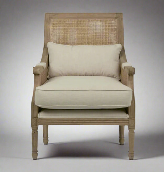 Indulge in the timeless design of this Hicks Caned Armchair with its carved oak frame, rattan back, and natural cotton upholstery. The plush seat and back cushions, both removable for easy cleaning, make it perfect for any living room or bedroom. Add a touch of elegance and comfort to your home with this must-have piece. Front