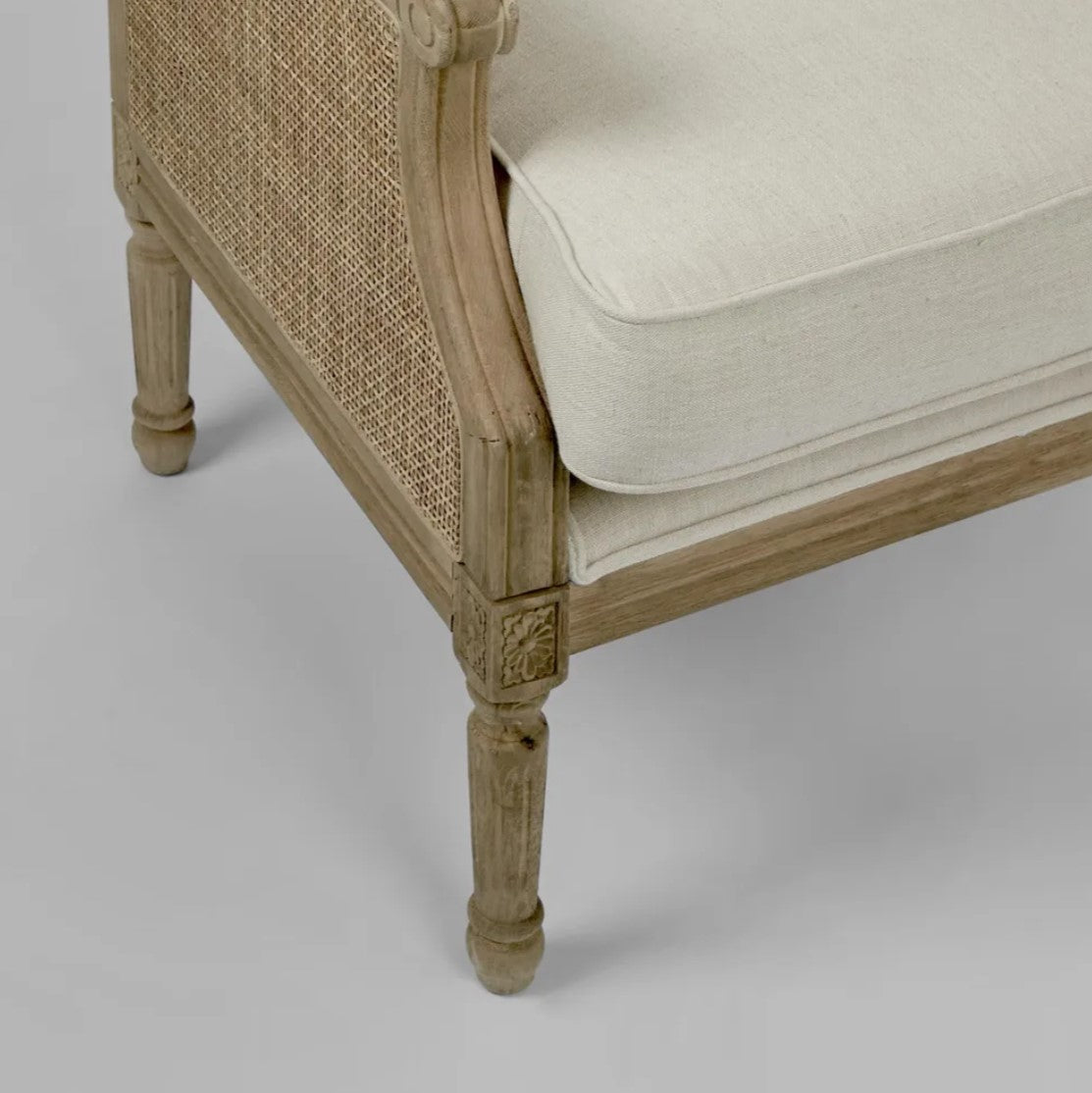 Indulge in the timeless design of this Hicks Caned Armchair with its carved oak frame, rattan back, and natural cotton upholstery. The plush seat and back cushions, both removable for easy cleaning, make it perfect for any living room or bedroom. Add a touch of elegance and comfort to your home with this must-have piece. Corner