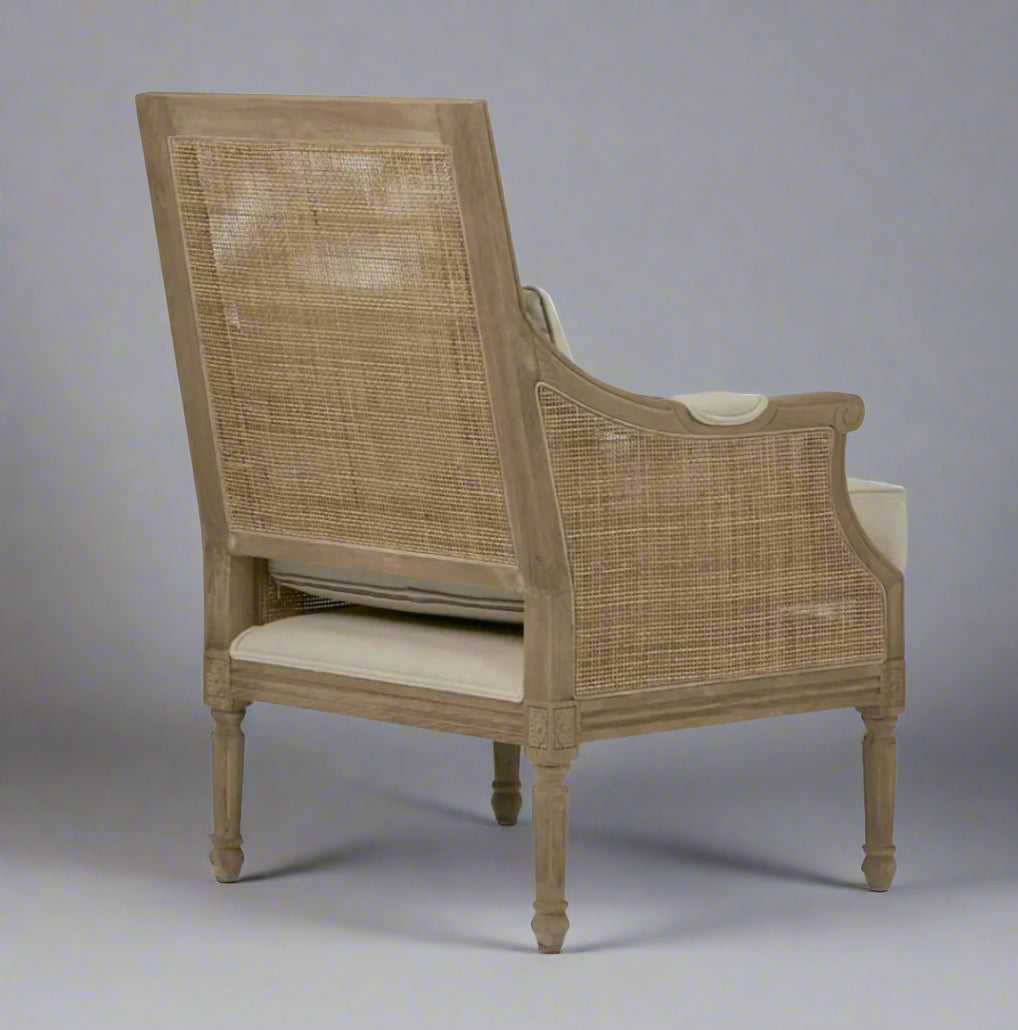 Indulge in the timeless design of this Hicks Caned Armchair with its carved oak frame, rattan back, and natural cotton upholstery. The plush seat and back cushions, both removable for easy cleaning, make it perfect for any living room or bedroom. Add a touch of elegance and comfort to your home with this must-have piece. Side