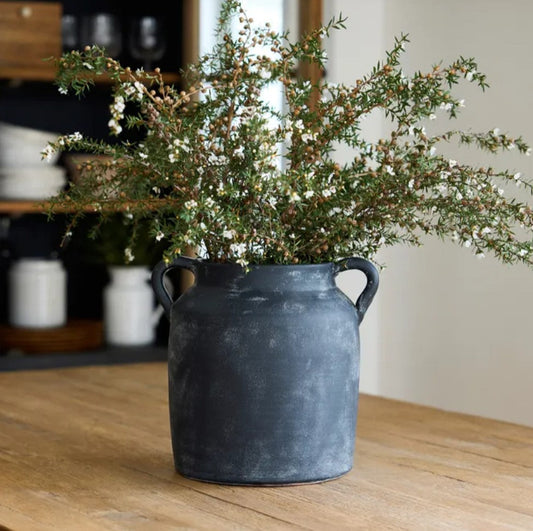 Transform your space with this Oliver Black Distressed Terracotta Pot, featuring a timeless and rustic charm that exudes character and elegance. The black and white distressed finish and small handles make it perfect for styling on a coffee table, shelf, or table. Get ready to add a touch of sophistication to your home!