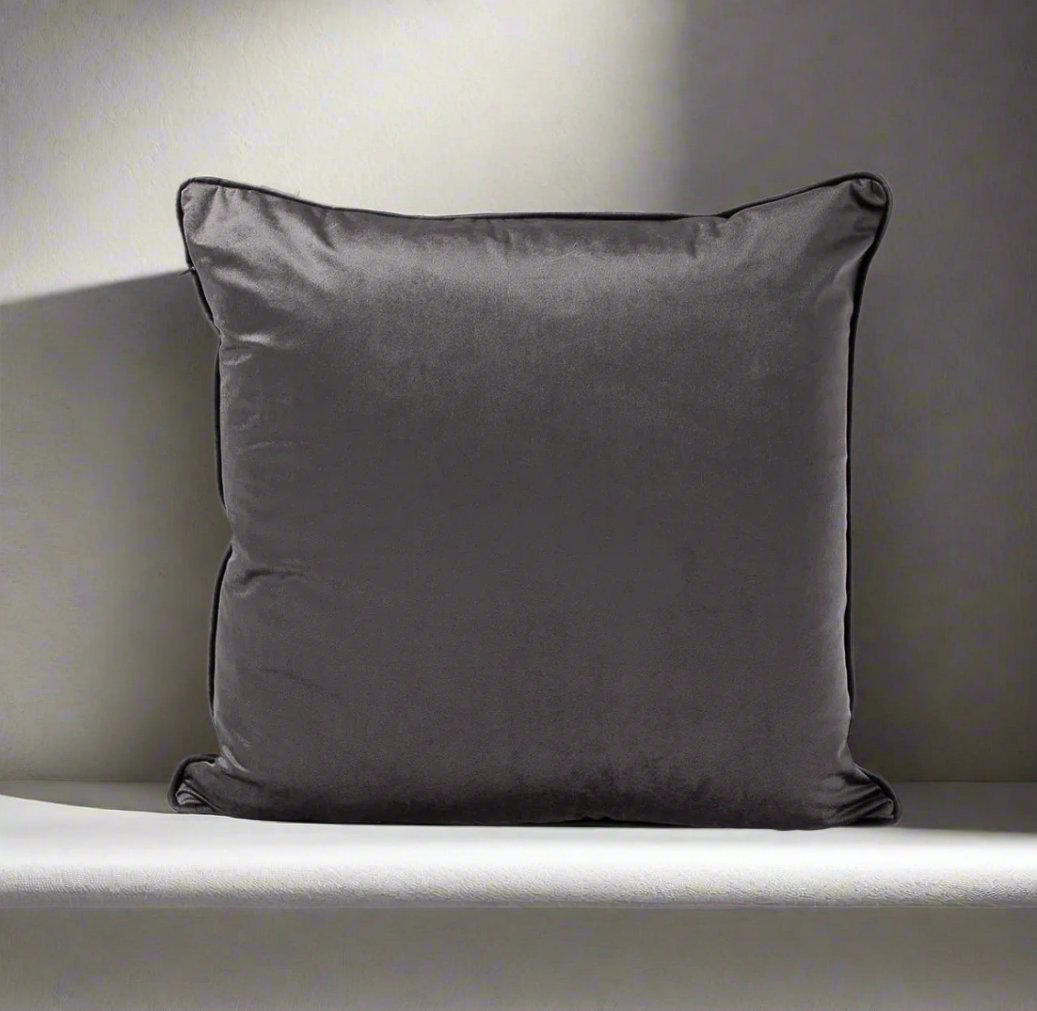 Indulge in the softness of our Dark Grey Velvet Cushion 55cm x 55cm. This cushion adds style and luxury to any space, and comes with a concealed zipper for easy use. Filled with feather inserts for ultimate comfort and machine washable on a delicate cycle.