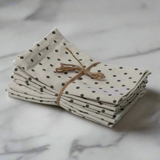 Stack of polka dot napkins tied with twine on a light gray background