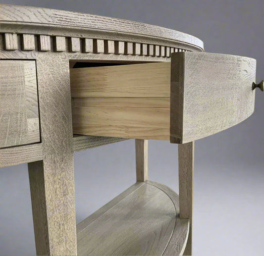 Experience the timeless beauty of the Claude Weathered Oak Curved Console Table. Crafted from solid oak and oak veneer in a stunning weathered oak finish, this table is perfect for any hallway, living room, or bedroom. It features a single dovetailed drawer with a sleek brass handle, adding both functionality and a touch of elegance.