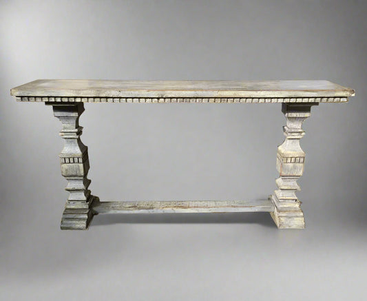 This stunning timber console table is crafted from recycled Oregon and boasts a rustic grey distressed paint finish. The intricately carved pedestal legs add a touch of elegance, making it the perfect piece to style in a hall, dining room, or behind a sofa.