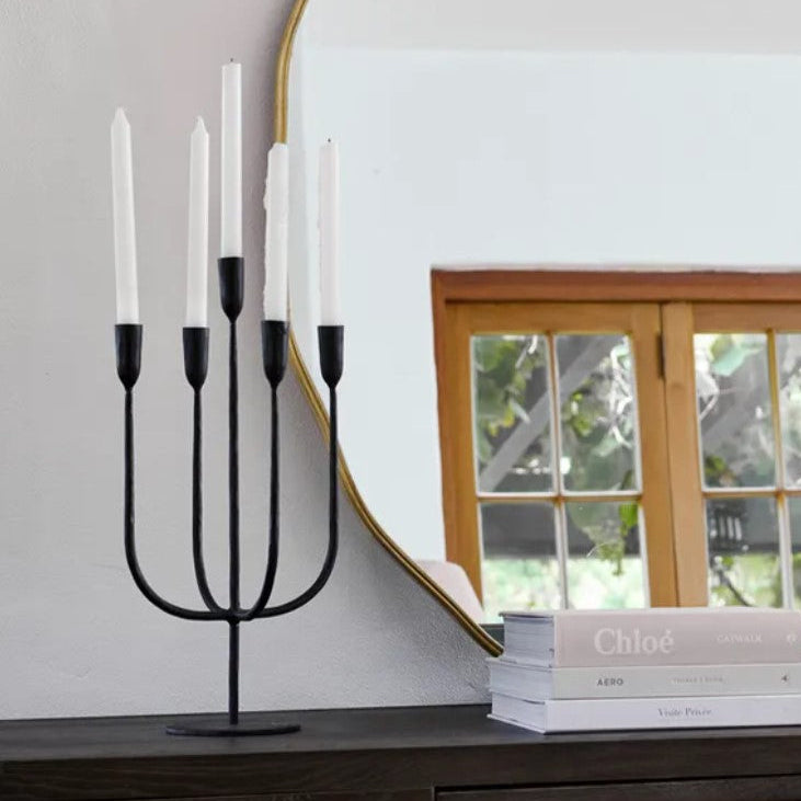 Experience the classic and bold personality of the Dax 5 Light Candelabra Taper Candle Holder, crafted from hand-forged and cast iron to add a touch of sophistication to your tabletop or console vignette.