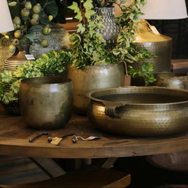This Basque Bowl features handles and a hammered antique brass finish, crafted from aluminium. It serves as a striking table centrepiece or a bold statement piece for your home.