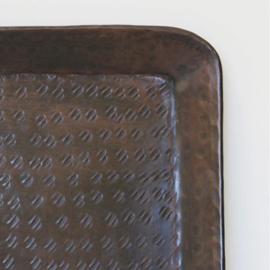 The Luxor Rectangular Tray features a hammered antique brass finish, crafted from aluminium. This versatile tray brings a beautiful warmth with it's brass finish and can be used as a statement decor piece for your home.