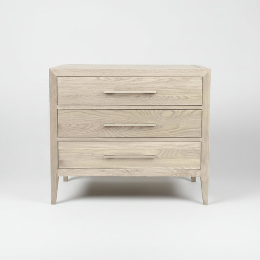 Wooden nightstand with three drawers on a light gray background