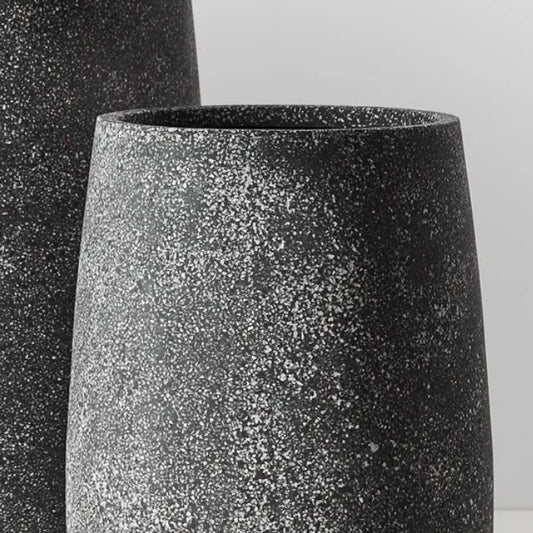 Transform your plant presentation with the Bodhi Grey Pot - Small. Crafted by hand from Poly Terrazzo, this modern and adaptable pot may display minor discrepancies in dimensions, surface feel, and hue due to its artisanal composition. Its versatility allows it to thrive both indoors and outdoors, and its integrated drainage feature promotes optimal plant development.