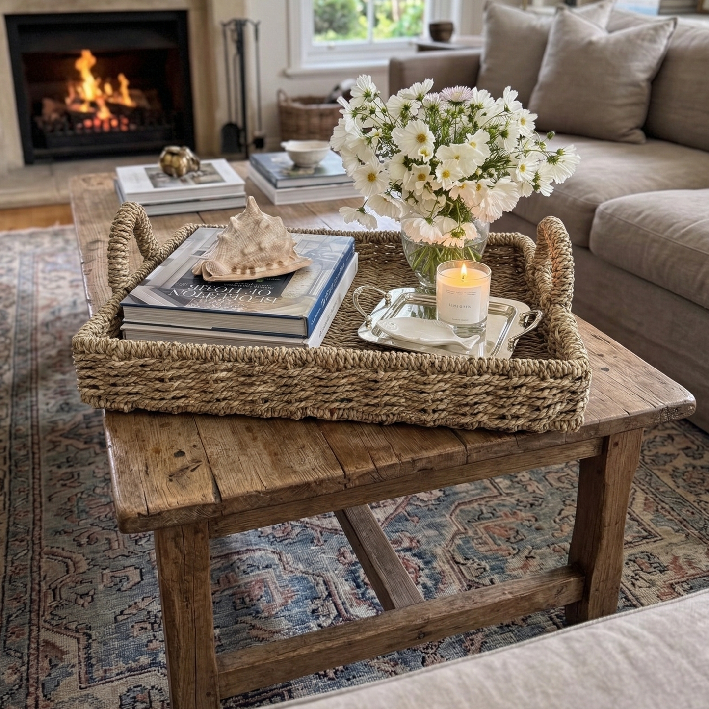 Cozy living room with a fireplace, bookshelf, and coffee table with seagrass tray